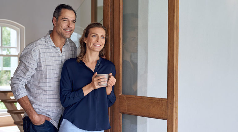 Couple devant une porte de maison